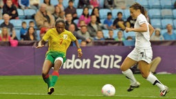 Kameruns Gabrielle Onguene (l.) greift ihre Gegenspielerin an.