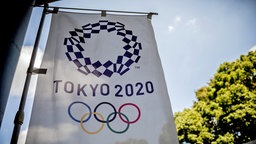 Eine Fahne mit dem Logo für die Olympischen Spiele 2020 in Tokio. © dpa picture alliance Foto: Michael Kappeler