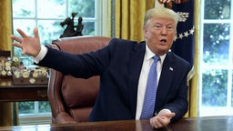 US-Präsident Donald Trump sitzt an einem Schreibtisch im Weißen Haus in Washington. © dpa picture alliance/nescom Foto: Yuri Gripas