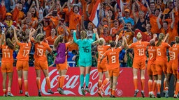 Die niederländischen Nationalspielerinnen jubeln nach einem Spiel vor ihren Fans im Stadion. © dpa picture alliance/Xinhua Foto: Xiao Yijiu
