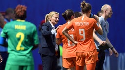 Szene aus dem WM-Spiel Niederlande gegen Kamerun: Trainerin Sarina Wiegman steht mit ihren Spielerinnen Sherida Spitse und Vivianne Miedema an der Seitenlinie zusammen. © imago images