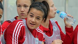 Die Fußballspielerin Lena Lotzen  sitzt im Trikot der deutschen Fußball-Nationalmannschaft auf der Ersatzbank. © imago images 