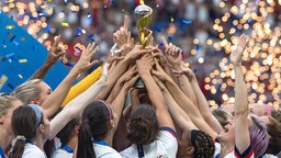 Die US-amerikanischen Fußballerinnen strecken den WM-Pokal in die Höhe © imago images / Xinhua 