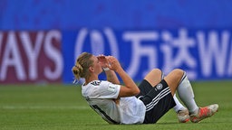 Nationalspielerin Alexandra Popp liegt nach einem Fußball-Länderspiel enttäuscht auf dem Rücken auf dem Rasen. © dpa picture alliance/NurPhoto Foto: Jose Breton