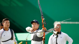 Der Südkoreaner Lee Seungyun (M.) gewinnt mit seinem Mannschaftskameraden Ku Bonchan (l.) die Goldmedaille im Bogenschießen. © DPA Bildfunk Foto: Diego Azubel