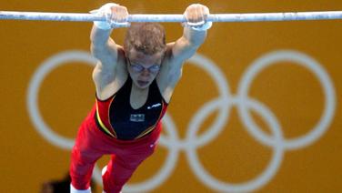 Der deutsche Turner Fabian Hambüchen landet bei den Olympischen Spielen 2004 auf dem siebten Platz am Reck. © picture-alliance / dpa Foto: Gero Breloer