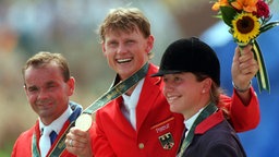 Ulrich Kirchhoff (Mitte) feiert Einzelgold in Atlanta 1996 vor Willi Melliger und Alexandra Ledermann © dpa/Gero Breloer Foto: dpa/Gero Breloer